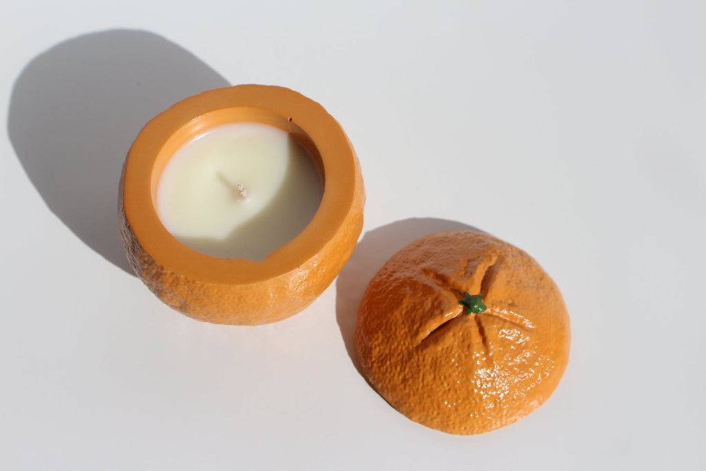 Open mandarin candle with a lid on the side